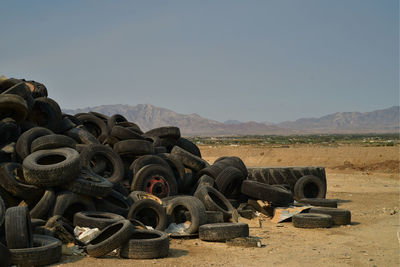 Stack of stones on field against clear sky