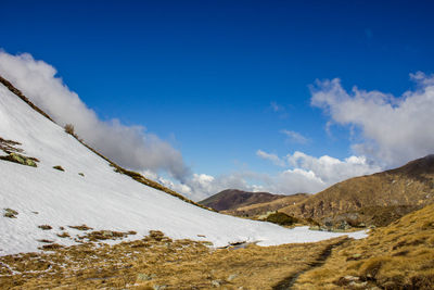 Scenic view of mountains against cloudy sky