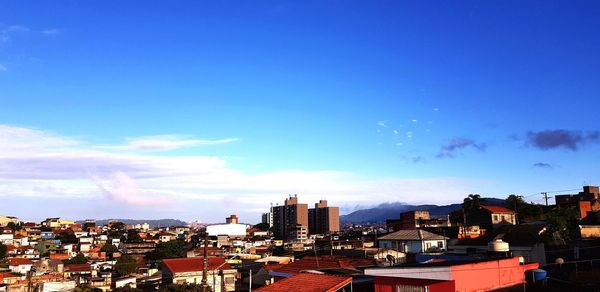 High angle view of buildings against blue sky