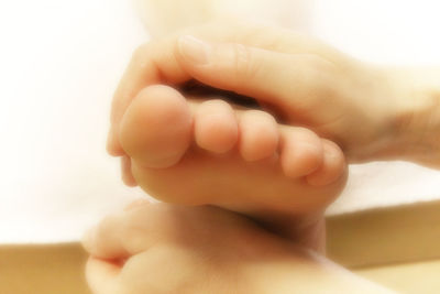 Close-up of cropped hand holding baby