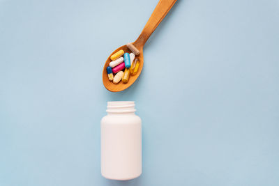 Close-up of pills in bottle against blue background