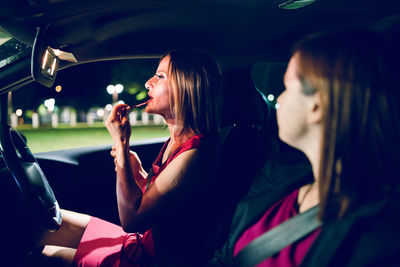 Side view of woman sitting in car