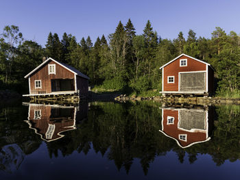 House by lake against building against sky