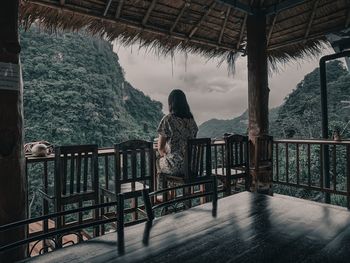 Rear view of woman standing on railing