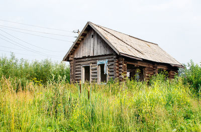 Abandoned house on field against clear sky