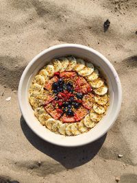 High angle view of dessert in bowl on sand