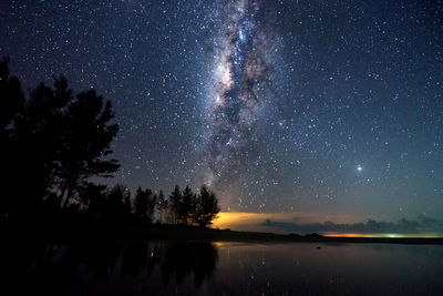 Scenic view of lake against sky at night