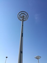 Low angle view of communications tower against blue sky