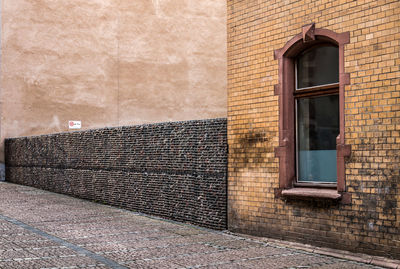 A facade, a fire wall and a stone wall in an old street of halle