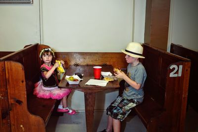 Siblings eating food at table