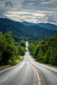 Road amidst trees against sky