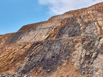 Low angle view of rocky mountains against sky