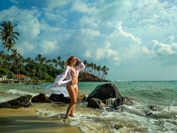 Full length of woman on beach against sky