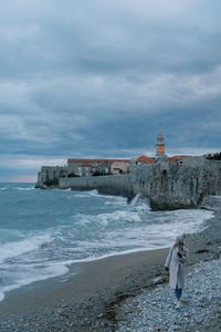 Lighthouse by sea against sky
