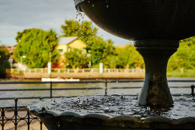 Close-up of water splashing on fountain against lake