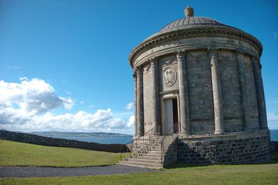Old built structure on field against sky