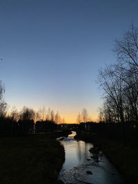 Scenic view of lake against clear sky during sunset