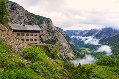 Scenic view of mountain range against cloudy sky
