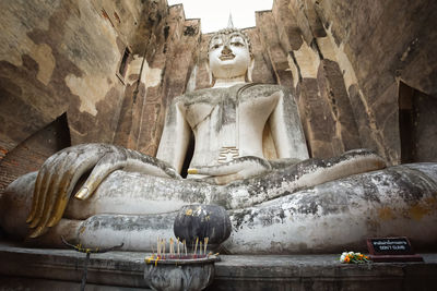 Buddha statue against historic building