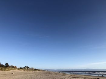 Scenic view of beach against blue sky