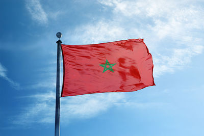 Low angle view of flag against blue sky