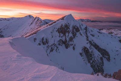 Scenic view of snowcapped mountains against sky during sunset