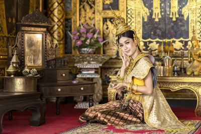 Portrait of smiling woman sitting in museum