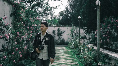 Full length of woman standing by flowering plants