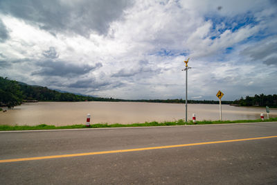 Empty road against cloudy sky