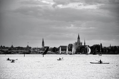 Boats in river with buildings in background