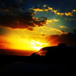 Silhouette car against sky during sunset