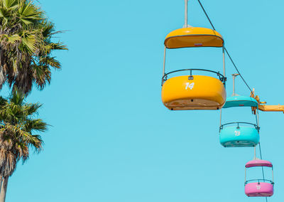 Three colorful cable cars against a clear blue sky.