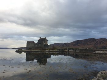 Reflection of building in lake against sky