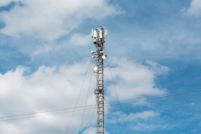 Low angle view of communications tower against blue sky