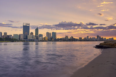 City at waterfront during sunset