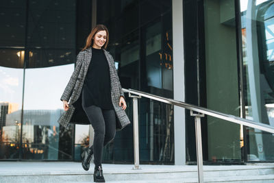 Portrait of young woman standing in city