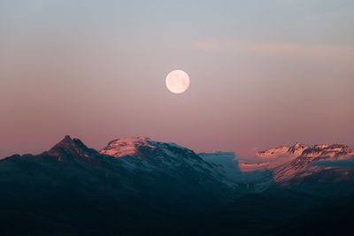 Scenic view of snowcapped mountains against sky at sunset