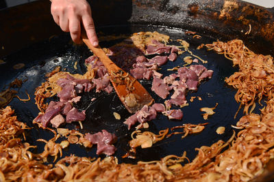 Meat and fried onions on cooking pan