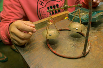 Midsection of using old weighing scale on table