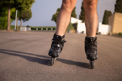 Low section of man roller skating on road