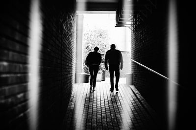 Rear view of people walking in subway