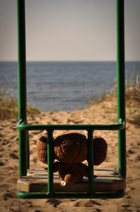 Cheburashka on beach against sky