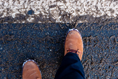 Low section of man standing on road