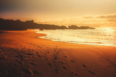 Scenic view of beach against sky during sunset