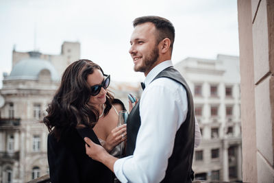 Side view of couple standing in city