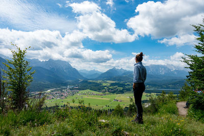 Side view of woman standing on field against sky