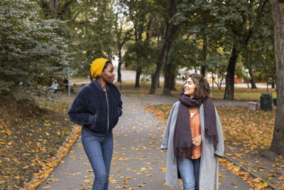 Two young women walking in park