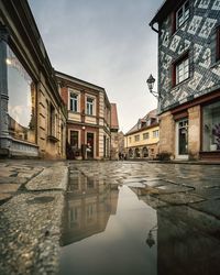 Reflection of building in puddle on street