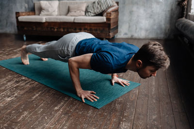 High angle view of man lying on hardwood floor