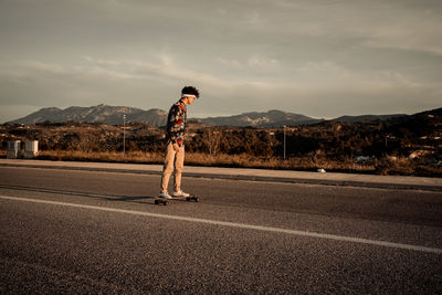 Full length of man standing on road against sky